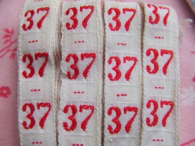 Ancien ruban de couleur blanche tissé numéro rouge, grand chiffre n°37