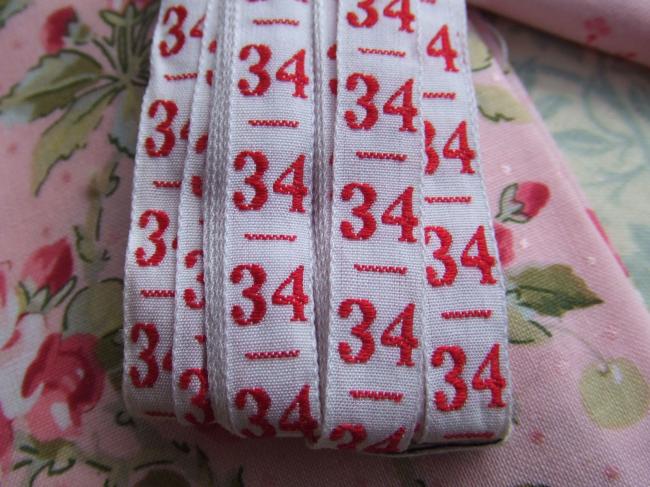 Ancien ruban de couleur blanche tissé numéro rouge, grand chiffre n°34