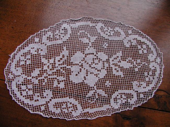 Gracious pair of hand made oval filet lace doilies depicting roses