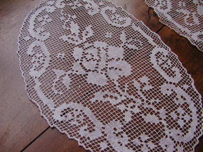 Gracious pair of hand made oval filet lace doilies depicting roses