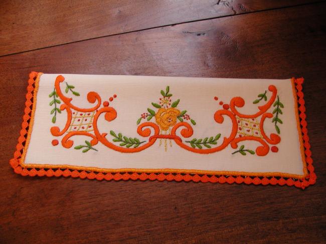 Lovely napkin case with hand-embroidered volutes and orange flowers