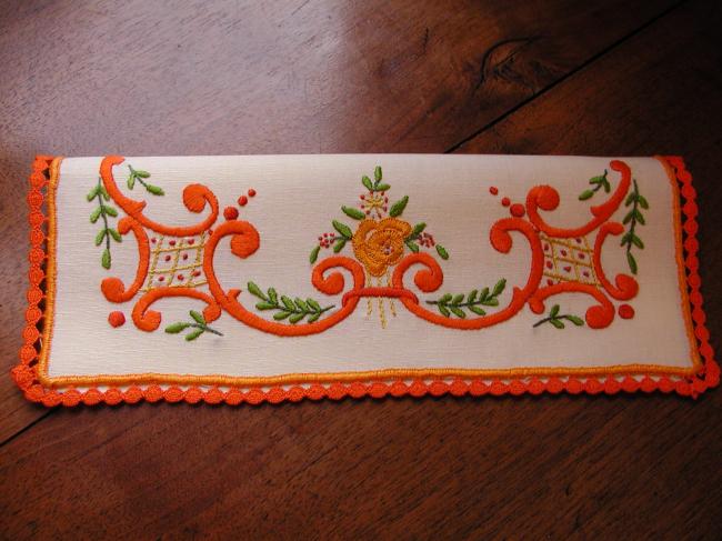 Lovely napkin case with hand-embroidered volutes and orange flowers