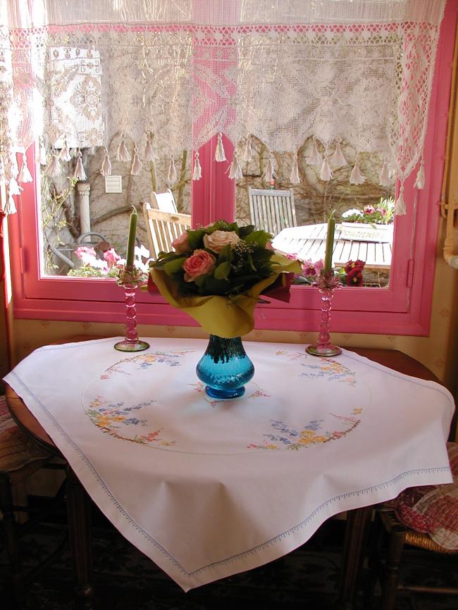 Really romantic tablecloth with embroidered summer flowers in a garden