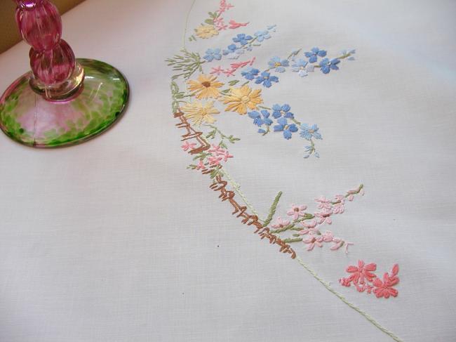 Really romantic tablecloth with embroidered summer flowers in a garden