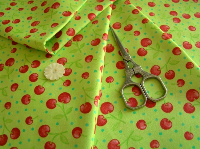 Coupon de coton à fond vert pomme avec impression de cerises et petits pois