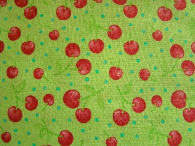 Coupon de coton à fond vert pomme avec impression de cerises et petits pois