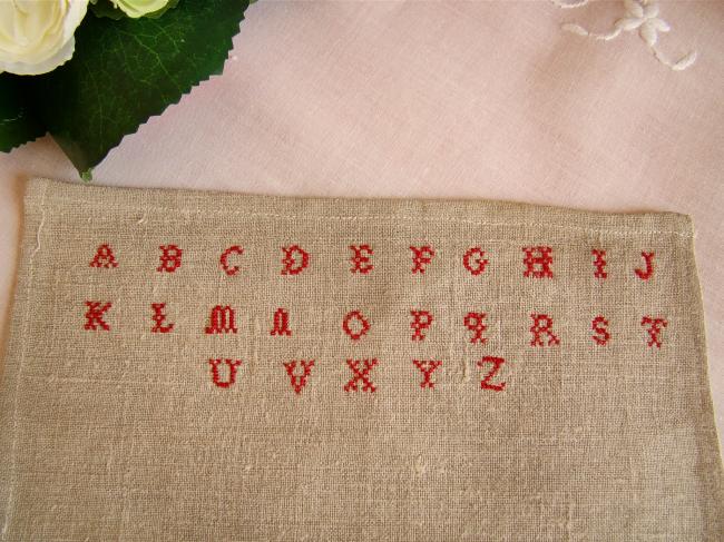 Tiny sampler made in red cross stitches on hemp, circa 1900