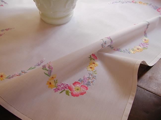 Really romantic tablecloth with embroidered summer flowers in a garden