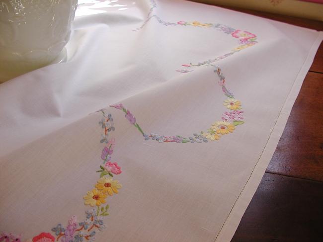 Really romantic tablecloth with embroidered summer flowers in a garden