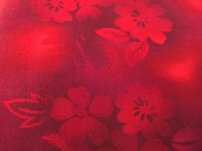 Coupon de coton à fond rouge, effet de lumière, impression de fleurs